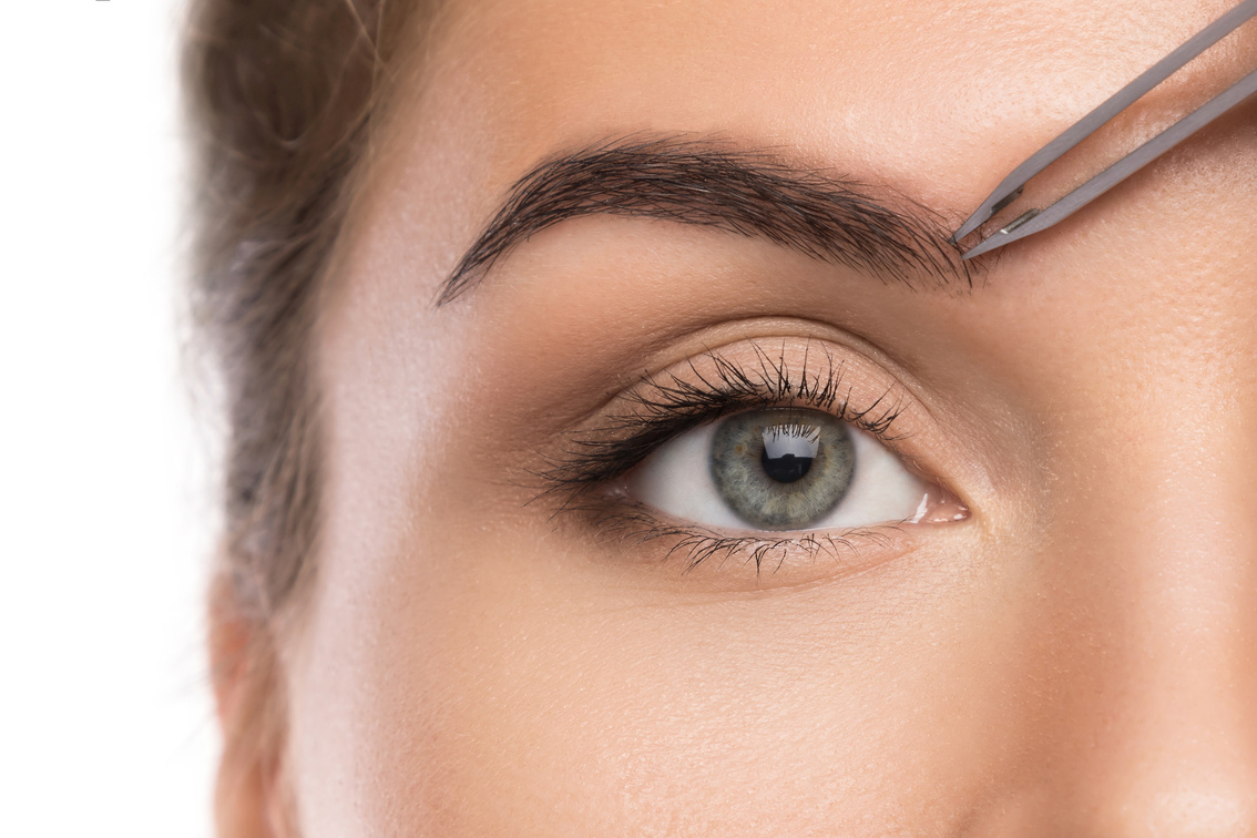 Woman tweeze eyebrows